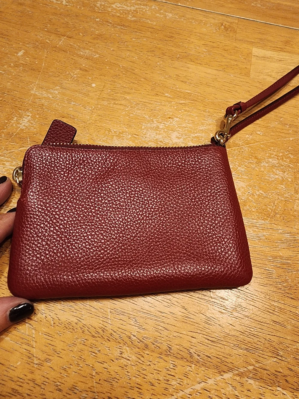 red polished pebble leather Coach wristlet, featuring gold-tone hardware